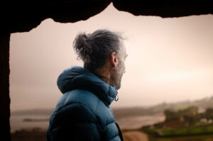 Photo d’Yvain Lucas, de profil, dans un paysage côtier de la baie de Morlaix